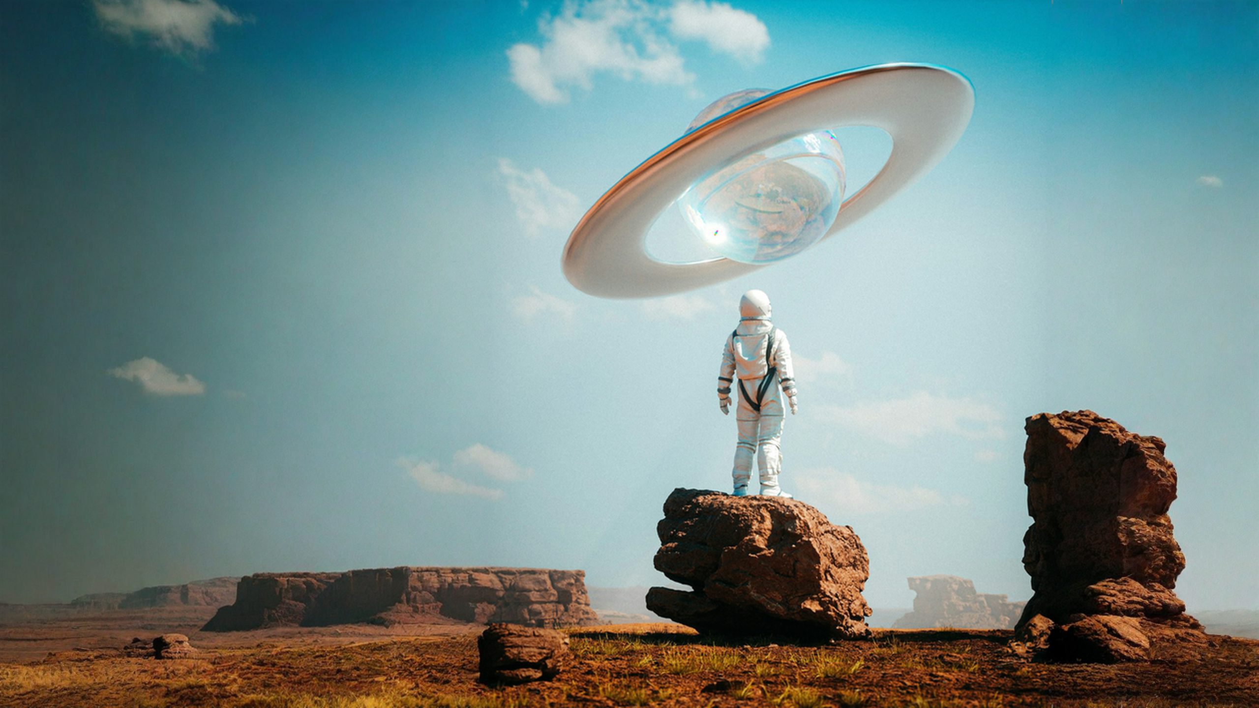 Astronaut on a desert rock beneath a giant glass ringed planet